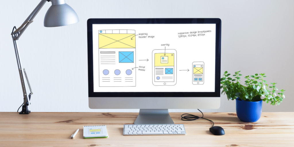 computer on desk showing wireframe images